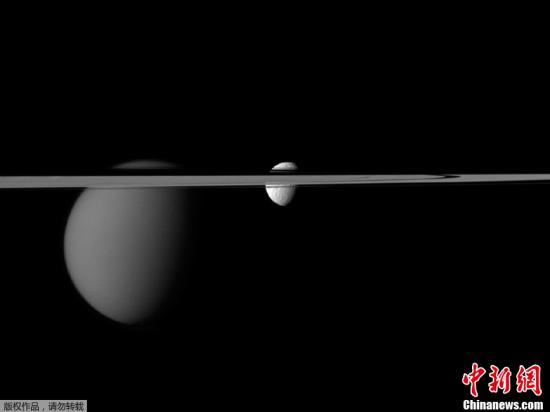 美国国家航空航天局（NASA）近日公布了“卡西尼”号飞船发回的土星环“横切”两颗土星的卫星、形成“一环穿两珠”奇景的照片。从图片中可以看到，“土卫三”以及土星最大的卫星“土卫六”都正好处在土星环的位置，就如被土星环串起来的珠子一般。