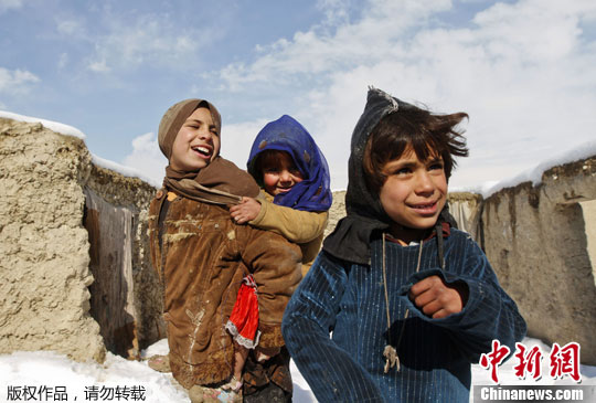 资料图：阿富汗儿童在避难帐篷外玩耍。