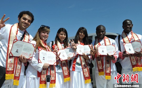 资料图：六名外国学生展示毕业证。新时社发 翟羽佳 摄