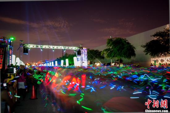 资料图：美国休斯敦举办“荧光长跑”，夜晚现“霓虹海洋”。