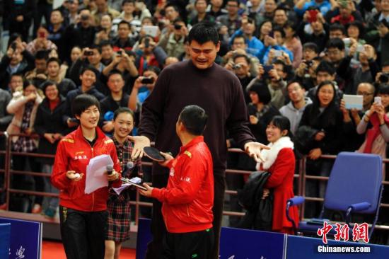 2013年12月3日，国家乒乓球队总教练刘国梁率领众队员在上海交通大学参加“国乒上海交大行”活动。身为交大学生的姚明也特意前来助阵，并在现场与乒乓世界冠军们切磋球技。/p中新社发 汤彦俊 摄