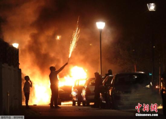 资料图：当地时间2014年1月1日，法国诺伊霍夫，警察在扑灭被焚烧的汽车。据外电报道，法国内政部长曼努埃尔·瓦尔斯1日发布声明说，法国在跨年夜有1193辆汽车被烧毁。这是法国政府三年来第一次公布跨年夜被焚车辆数据。一些年轻的狂欢者焚烧路边车辆已成为法国跨年夜的一个陋习。