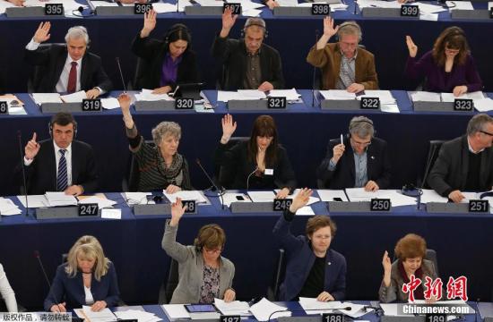 当地时间3月12日，法国斯特拉斯堡，欧洲议会部分议员举起美国窃听门嫌疑人斯诺登的多色头像标牌，参加审议美国国安局监听项目及其对欧盟权益的影响议程投票。