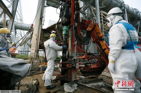 资料图：日本福岛县，东电员工在受损的福岛第一核电站附近建筑冰墙。