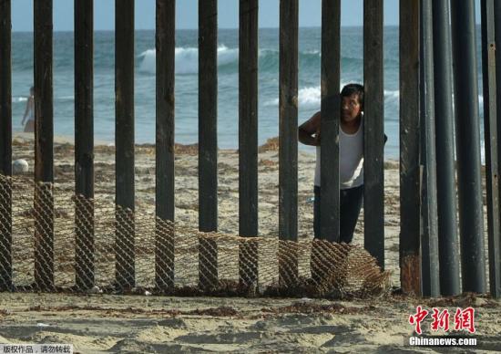 8月20日，圣地亚哥，一道划分美墨边界的栅栏旁，一名男子站在墨西哥这边眺望美国。