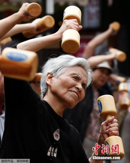 当地时间9月15日，日本东京巢鸭区，日本老人们手持木质哑铃齐跳“广场舞”宣传健康活动以此庆祝敬老日的到来。