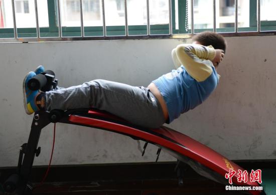 4月15日，杭州建新小学的一名小胖墩儿们正在减肥训练课上练习仰卧起坐。2014年期末的体质测查显示，该校858名学生中有5%的孩子BMI指数处于肥胖，而其中最重的一个孩子读五年级，身高1.61米，体重却达到了81公斤。为此，学校设立“熊猫班”给超重的4名小胖墩儿们集体减肥，其中效果最好的学生成功减重6斤。<a target='_blank' href='http://www.chinanews.com/'>中新社</a>发 李晨韵 摄