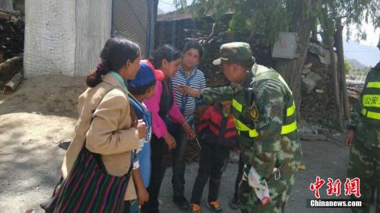 5月12日，西藏公安边防总队侦查支队吉隆站的晋美多吉正在安抚当地群众。5月12日下午15时05分，尼泊尔再次发生7.5级地震，西藏日喀则吉隆方向震感强烈。中新社发 杨鸿辉 摄