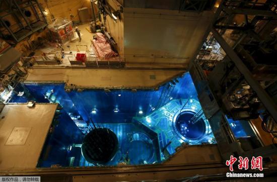 图为工作人员正将核燃料棒装填如反应堆内。