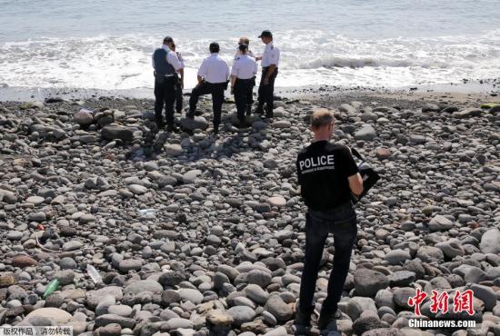 当地时间8月2日，法属留尼旺首府圣但尼附近的一处海滩上，警员正在现场对金属残片进行勘察。
