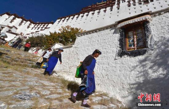 图为参与粉刷布达拉宫的藏族信教民众。 李林 摄