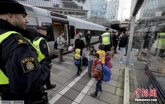 一列国际列车跨越厄勒海峡大桥来到瑞典马尔默，当地警察从列车中检查出多名难民偷渡，将他们带出车厢。