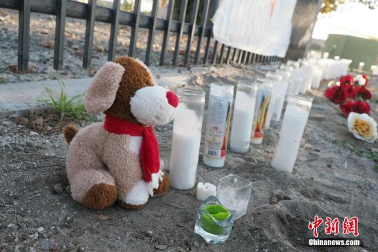 美国联邦调查局官员12月4日在圣贝纳迪诺市宣布，2日发生在该市的14亡21伤大规模枪击事件是恐怖主义行动。图为在枪击事件发生地不远的街口，许多民众摆上献花和蜡烛祭奠遇难者。 <a target='_blank' href='http://www.chinanews.com/'><p align=