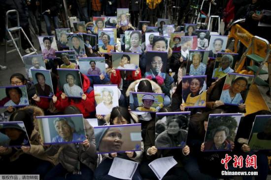 当地时间2015年12月30日，韩国首尔，当地民众手中高举慰安妇的照片，在日本使馆前集会抗议。