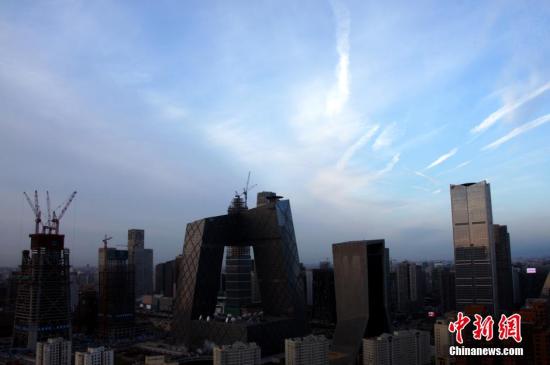 资料图：2016年1月4日，继雾霾三天后，北京迎来新年后的首个蓝天，半边天空被朝阳映得通红，初升太阳如同蛋黄。