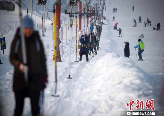 游客由滑雪场的拖牵索道牵引，逆势而上。　刘新 摄