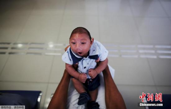 资料图：巴西累西腓康复中心，32岁的古斯塔沃・恩里克带着自己的儿子等待接受治疗。