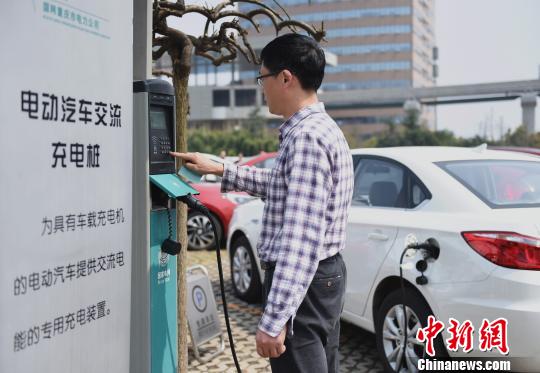 资料图：重庆市民在充电桩上为电动汽车充电。　周毅 摄