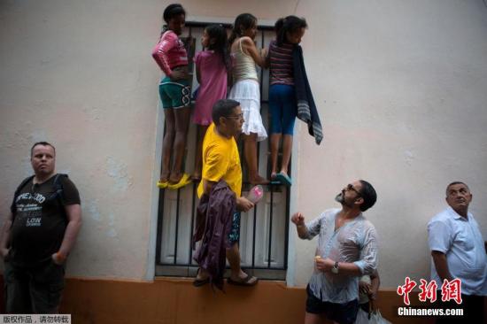 美国总统奥巴马抵达古巴首都哈瓦那开始访问，古巴哈瓦那儿童爬墙观望奥巴马到访。