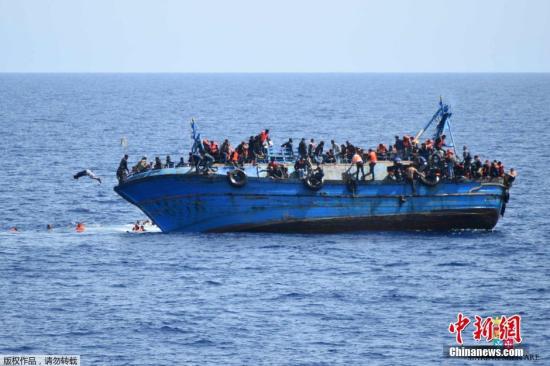 资料图：利比亚近海海域，一艘满载难民的船只即将倾覆，船上的难民纷纷跳海逃生。