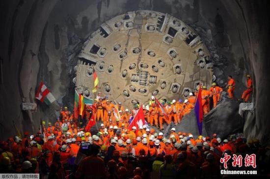 图为2000年10月15日，隧道工人们跟着巨大的钻头进行挖掘工作。在1992年，瑞士举行公投，决定兴建一条全新的横贯阿尔卑斯山的铁路隧道。这条隧道的中心线就是圣哥达基线隧道。圣哥达基线隧道在1996年的时候开始修建，全工程造价约103亿美元。（资料图）