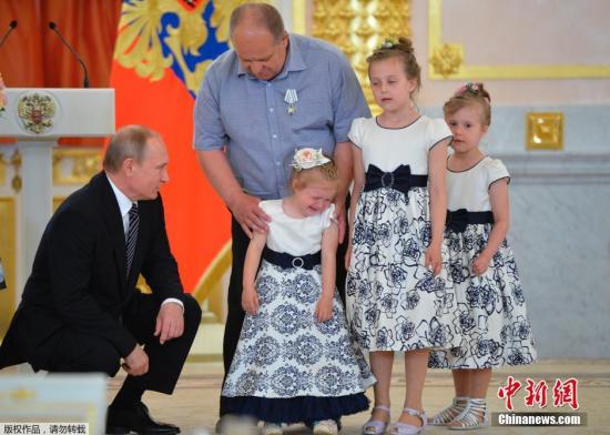 当普京为Klishov一家颁奖时，4岁小女孩嚎啕大哭，普京急忙蹲地安慰。