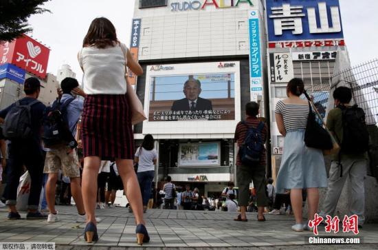 资料图：日本民众通过大屏幕观看明仁天皇的视频讲话。