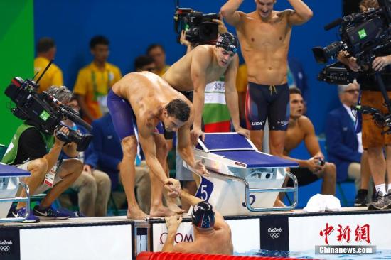 美国游泳名将菲尔普斯（图中弯腰握手者）在比赛中，可以看到他肩膀上的圆形印记。<a target='_blank' href='http://www.chinanews.com/' >中新网</a>记者 富田 摄
