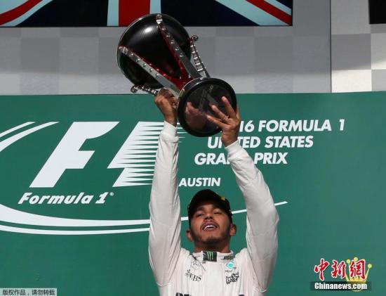 当地时间10月23日，汉密尔顿在颁奖仪式上举起冠军奖杯。当日，在2016年世界一级方程式大奖赛(F1)美国站比赛中，梅赛德斯车队英国车手汉密尔顿夺冠。