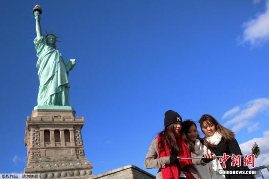 当地时间2016年10月28日，美国纽约，游客在自由女神像前自拍。自由女神像是法国在1876年赠送给美国的独立100周年礼物，今年是自由女神像抵达纽约自由岛130周年纪念。