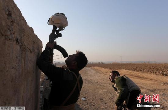 资料图：一名伊拉克士兵用头盔作为诱靶，来确定极端组织人员的位置。