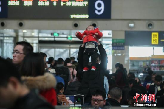 1月16日，武汉汉口火车站候车大厅里，一位乘客把手中的小孩举过头顶活动。<a target='_blank' href='http://www.chinanews.com/'>中新社</a>记者 张畅 摄