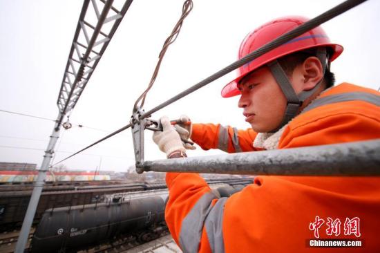 4月7日下午，哈尔滨铁路局供电段负责维护中国北疆对俄重要铁运线路——滨洲线的“接触网”技术工人们，正在对刚实现电气化的大庆安达区段进行首次越冬后的全面“体检”。去年11月，滨洲电气化铁路哈尔滨至齐齐哈尔段正式开通，作为中俄间的重要铁运线，运行了100多年的滨洲铁路进入“电气化时代”；至此，其线路“接触网”的维护工作今天全面展开，其电压达2.75万伏，距离地面6米多高，而从事电气化铁路维护、保养及抢修属于高压、高空、高危工种，被称作铁路“蜘蛛侠”。 记者 王舒 摄