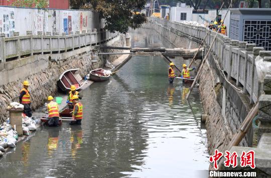 5月2日，在福州鼓台中心区水系综合治理项目包的屏东河项目现场，数十名工人在河道中将淤泥装进编织袋后运上岸。　刘可耕 摄