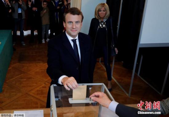 资料图：当地时间2017年5月7日，法国总统选举第二轮投票展开，多地民众参加投票。图为马克龙在投票点进行投票。