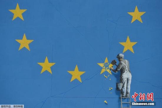 资料图：当地时间2017年5月7日，英国多佛，一名街头艺术家班克西创作了一幅画，画面中一名工人正从欧盟12星旗帜上抹掉一颗星，寓意着英国将脱离欧盟。