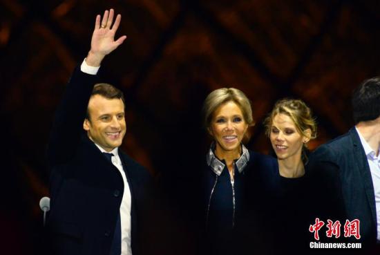 马克龙和妻子布丽吉特在巴黎卢浮宫前举行的庆祝胜选集会上。 中新社记者 龙剑武 摄