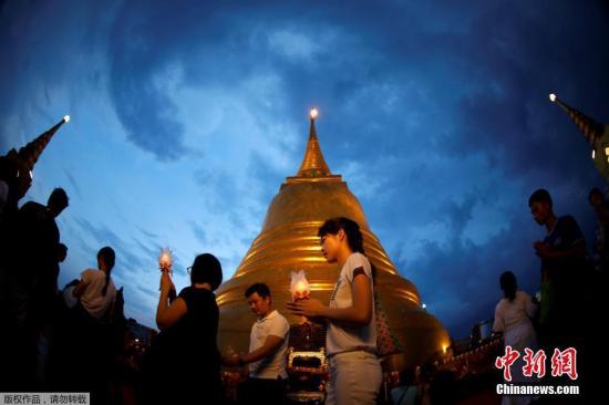 当地时间2017年5月10日，泰国各地民众庆祝卫塞节，民众手举蜡烛祈祷。