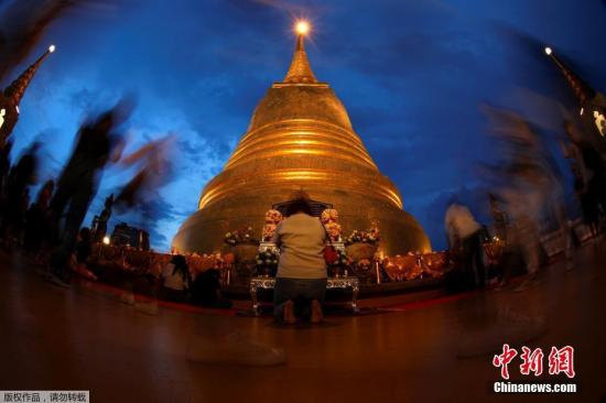 当地时间2017年5月10日，泰国各地民众庆祝卫塞节，民众手举蜡烛祈祷。