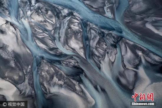 资料图：空中拍摄下的冰岛火山黑沙与冰川河相融合的壮观景象。图片来源：视觉中国