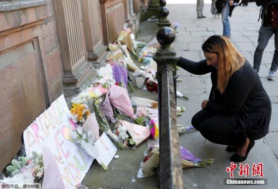 在曼彻斯特城市中心，市民们献上花朵和带有寄语的纸板，为爆炸案中的遇难者哀悼。