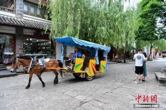 资料图：一对男女在丽江束河古镇内游玩。 中新社记者 任东 摄