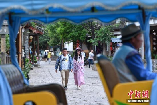 资料图：游客在丽江束河古镇内游玩。 中新社记者 任东 摄