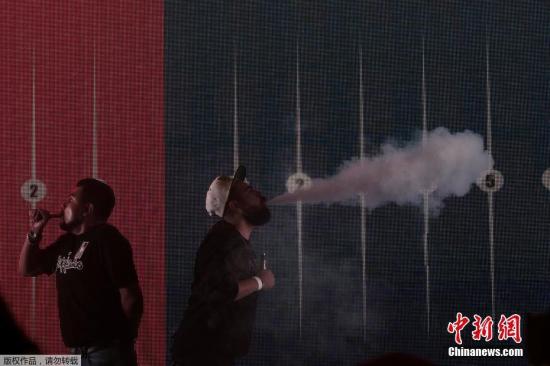 资料图：近日，墨西哥墨西哥城，墨西哥举办电子烟交易大会，参与者们在大会上用电子烟进行“吞云吐雾”。