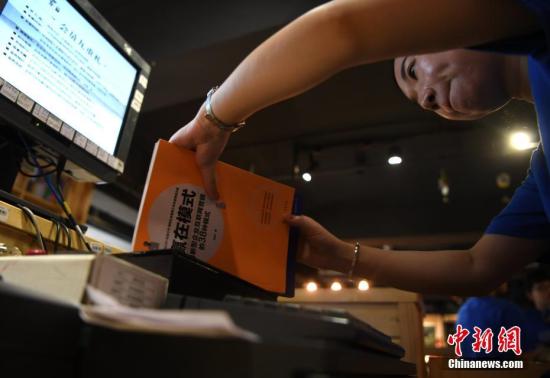 安徽合肥共享书店，工作人员对借阅书籍进行扫码登记。 中新社记者 韩苏原 摄