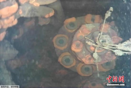 资料图：2017年，东京电力公司7月19日召开记者会，公布了首次使用水下机器人拍摄到的福岛第一核电站3号机组内的具体状况。机器人拍摄到的水下画面显示，3号机组受损严重，但熔落的核燃料并未被发现。此外，本应在压力容器下方供作业用的脚手架向下坠落，很可能是从压力容器中喷射出的高温核燃料残渣使其熔化所致。东电分析称，安全壳内的冷却水位有6.4米深，核残渣也很可能流到了安全壳底部。（视频截图）