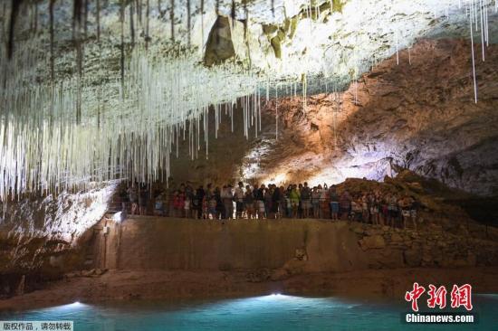 资料图：法国高温难耐，民众参观天然洞穴。当地持续高温，炎热难耐的天气让选择去洞穴参观的游客数量至少增加了10%。温度通常在15摄氏度的洞穴不仅有奇特的美景，还是天然的避暑胜地。