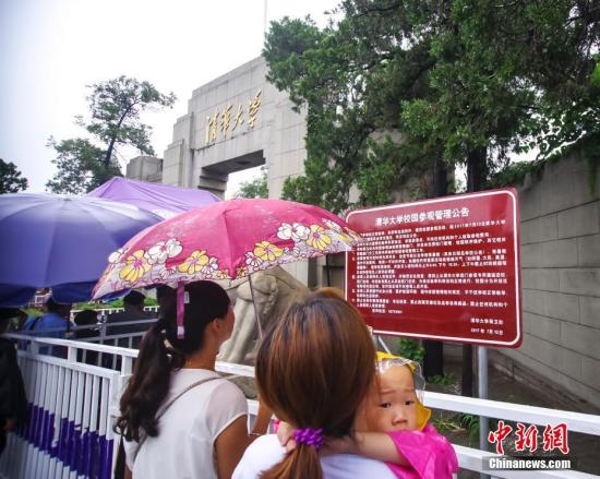 资料图：8月12日，游客冒雨在清华大学校门外排队等候入校参观。新时社记者 贾天勇 摄