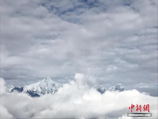 梅里雪山主峰在云雾里若隐若现。中新社记者 张若谷 摄 梅里雪山主峰在云雾里若隐若现。中新社记者 张若谷 摄