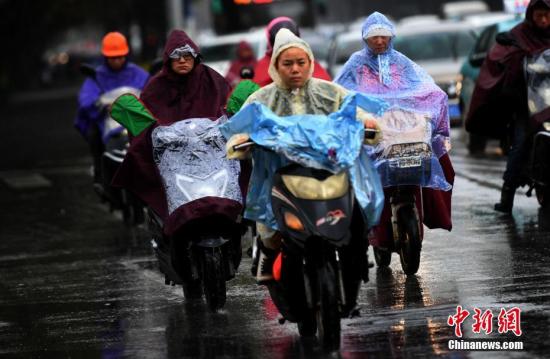 10月23日，昆明市区里冒雨赶路的民众。霜降节气，昆明迎来降雨又降温的天气，气温降到8℃。霜降是24个节气里，秋季的最后一个节气，从此天气开始渐冷。 <a target='_blank' href='http://www.chinanews.com/'>中新社</a>记者 李进红 摄